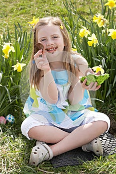 Girl Eating Chocolate Egg On Easter Egg Hunt