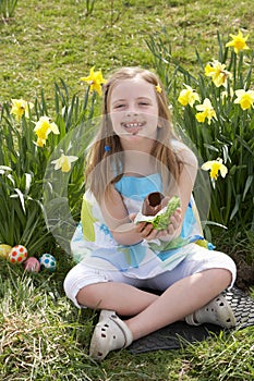 Girl Eating Chocolate Egg On Easter Egg Hunt