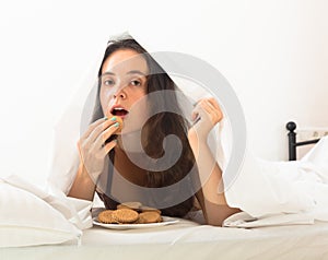 Girl eating cookies in bed