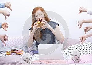 Girl eating donut on bed