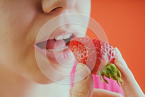 Girl eating fresh strawberries, close-up