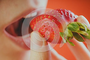 Girl eating fresh strawberries, close-up