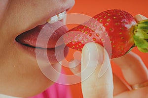 Girl eating fresh strawberries, close-up