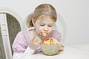 Girl eating fruit salad