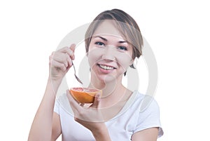 Girl eating grapefruit by the spoon