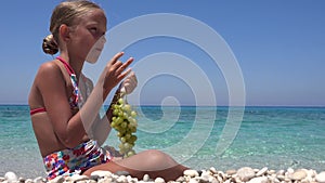 Girl Eating Grapes on Beach, Kid Eats Fruits on Seashore, Blonde Little Child Playing on Coastline, Sea Waves in Summer Vacation