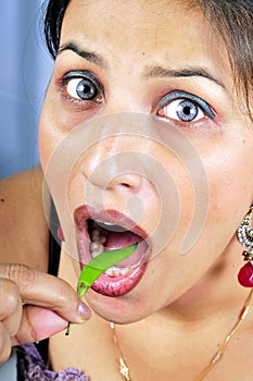 Girl eating green chilly