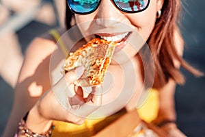 Girl eating Mexican fast food quesadilla on the beach. Healthy and tasty snack