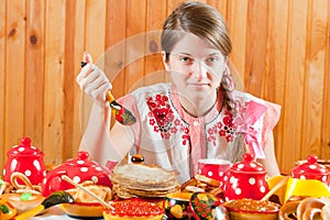 Girl eating pancake with caviare photo