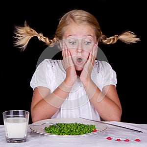 Girl eating peas with bugs on the table