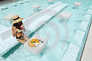 Girl eating pizza in pool