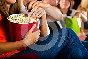 Girl eating popcorn in cinema or movie theater