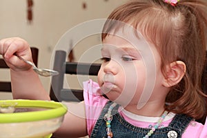 Girl eating porridge, disaffected face