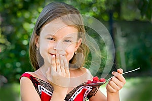 Girl eating raspberry