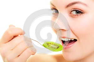 Girl eating slices of kiwi fruit. Healthy diet.