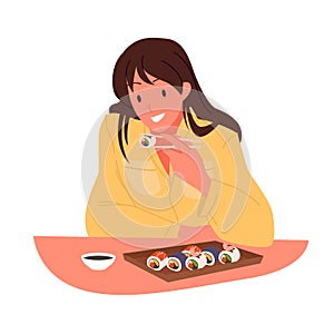 Girl eating sushi at table of restaurant with Japanese cuisine, woman holding chopsticks