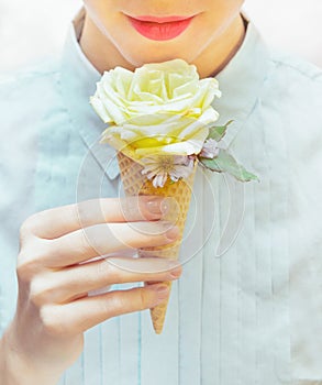 Girl is eating an unusual ice cream. Rose in waffle cone.