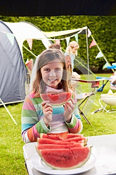 Girl Eating Watermelon Whilst On Family Camping Holiday