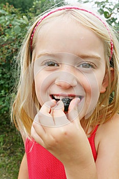 Girl eating wild blackberries