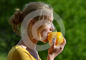 Girl eating yellow pepper