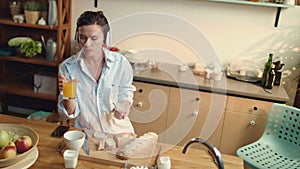 Girl eating yogurt baguette grapes in kitchen. Woman drinking orange juice.