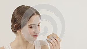 The girl eats a burger and enjoys it. Enjoy food. Caloric food.