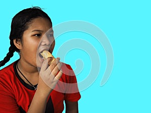 The girl eats hot dog Happily Isolated on a yellow background. Embed clipping path. Junk food concept.