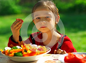 Girl eats vegetables photo