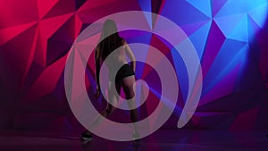 Girl elegant dance twerk in shorts on bright graphic background. Slow motion