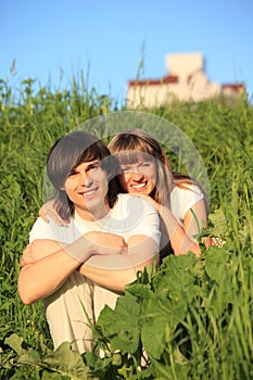 Girl embraces guy behind for shoulders