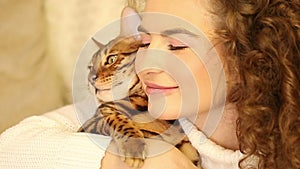 Girl embraces and kisses a Bengal cat. Pet.
