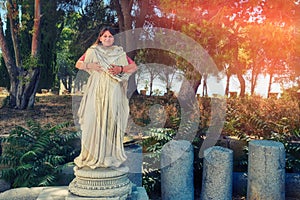 Girl embracing a statue of ancient Greece or antique Rome