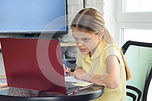 The girl is engaged in additional tutoring online photo