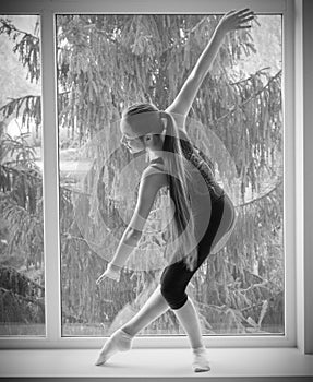 Girl engaged art gymnastic on window