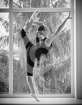 Girl engaged art gymnastic on window