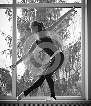 Girl engaged art gymnastic on window