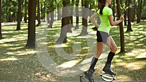 The girl is engaged in fitness in the forest. Coach for Kangoo Jump. A popular kind of aerobics