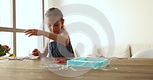 Girl engaged in hobby using beading kits for jewellery making