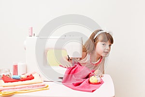 The girl is engaged in needlework using sewing machine