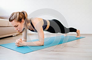 Girl is engaged in sports at home online workouts. fitness exercise -  plank