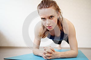 Girl is engaged in sports at home online workouts. fitness exercise -  plank
