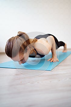 Girl is engaged in sports at home online workouts on laptop. pushups and plank