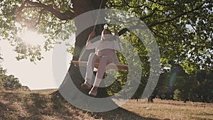 Girl enjoy spinning on rope swing with hair flowing