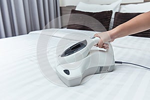 Girl enjoy using mite vacuum cleaner using cleaning bed mattress