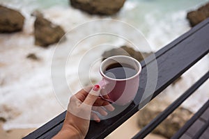 Girl enjoying morning coffee on stormy day at sea