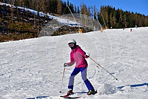 Girl enjoying and raises the hand during skiing on snow