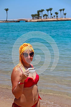 Girl enjoying relax drinking coffee on beach. Woman relaxing standing in sea