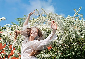 Girl enjoying springtime near blooming trees