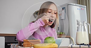 Girl enjoys bowl of cereal with milk healthy start in safe home atmosphere Girl's breakfast is time of care and