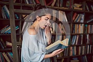 A girl enthralled looks into the book with astonishment. Shocking an unexpected intrigue story.